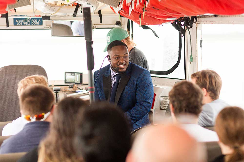 Competitor presenting their business pitch to panel of judges on duck boat.