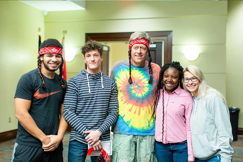 Kent Taylor, Founder, CEO and Chairman of Texas Roadhouse poses with students. 