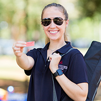 Female student holding up winning ticket and prize