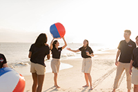 Ambassadors playing with beach ball on the beach