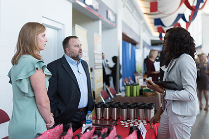 Female student talking with a male and female from accounting firm