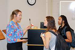 Two female students talking to female presenter