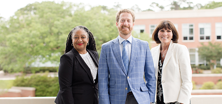 Featured Alumni standing in front of Meisler Hall