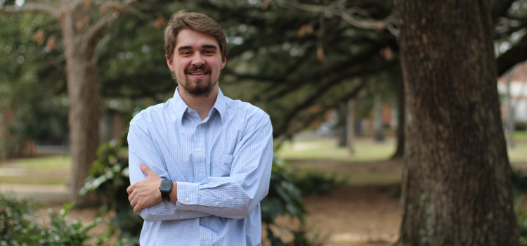 Caleb Lambert standing outside on campus.