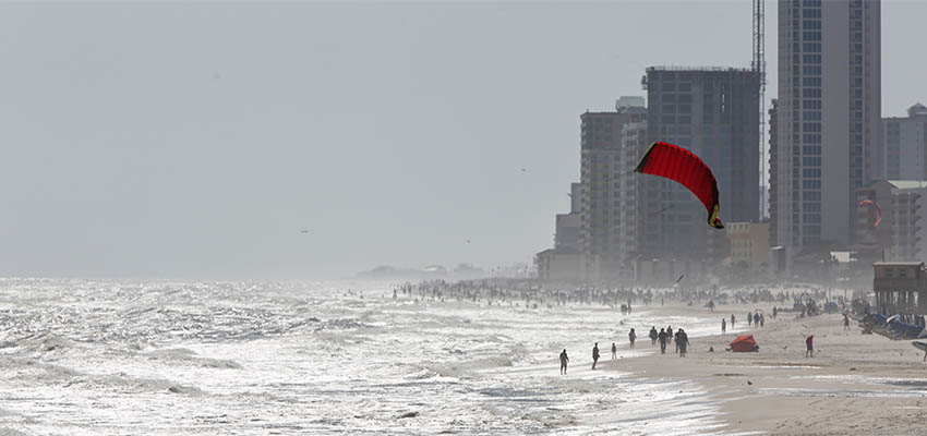 People walking on beach with condos