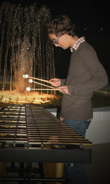 Ryan Boehme performing percussion recital at night with lighted fountain of Laidlaw in the background