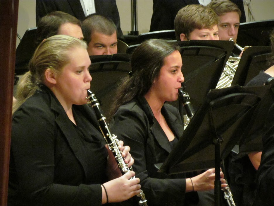 close-up of 5 USA Symphony Band members playing their instruments during performance on stage