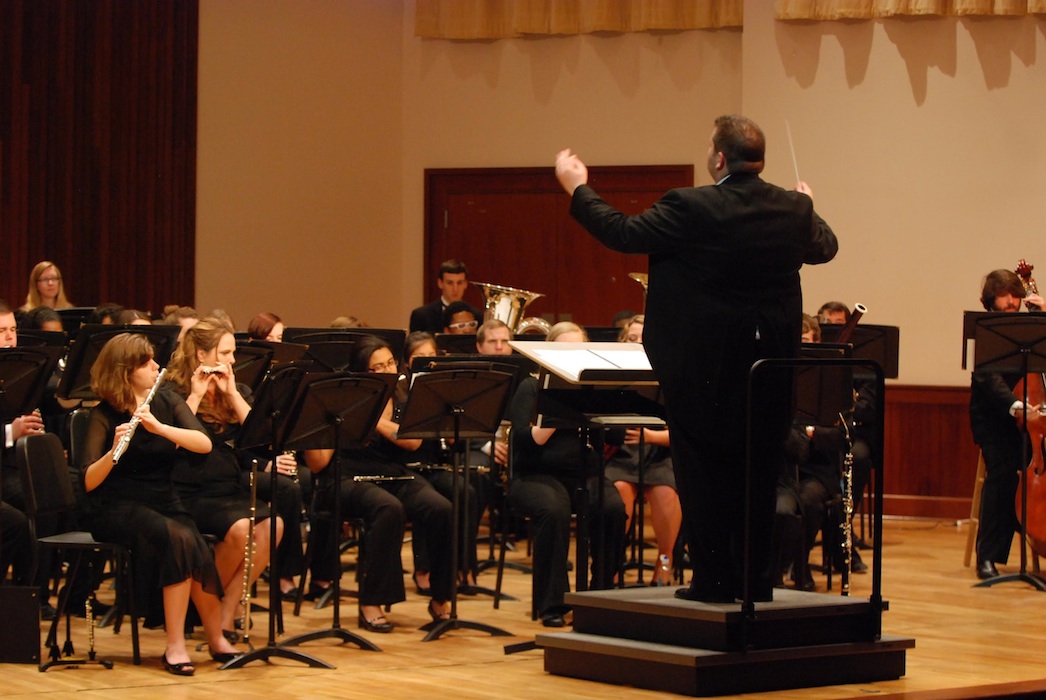 USA Symphony Band and Wind Ensemble performing on stage under direction of Dr. Jason Rinehart