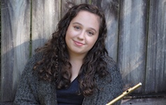 Pictured artistically in her back yard in front of a fence, holding her flute, is Hanna Ardrey.