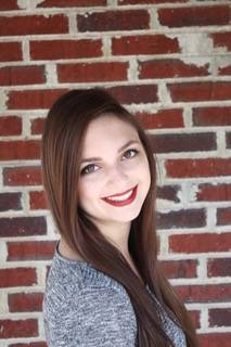 Elizabeth Bemis standing in front of brick wall