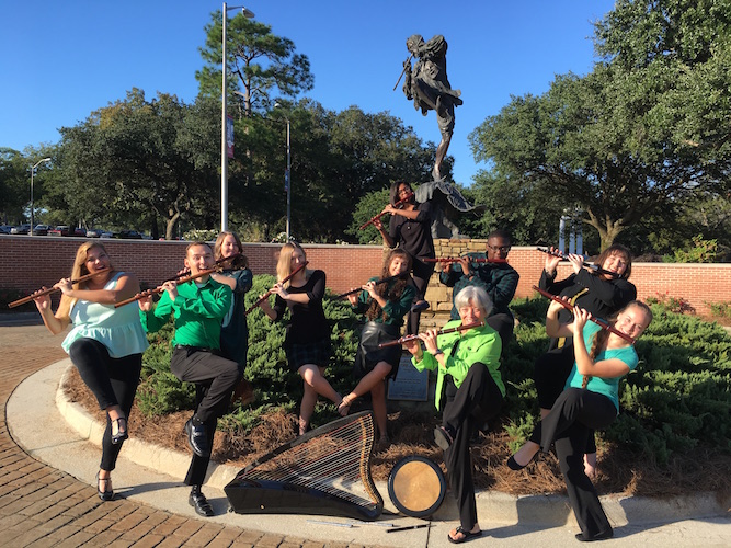 USA Celtic Crue folk flute ensemble is pictured outside the Laidlaw Performing Arts Center, all of them balanced on one leg in the manner of Jethro Tull flutist Ian Anderson.