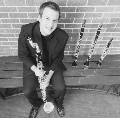 Dr. Kip Franklin seated on bench with 4 different instruments standing beside him