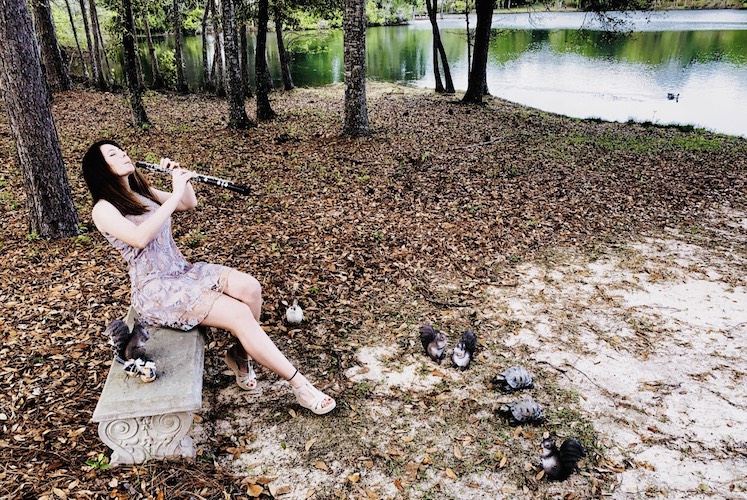 Oboist Tiffany Fresne pictured in a local park serenading various wild creatures, including the resident turtles.