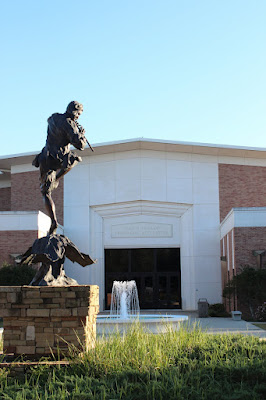 bronze statue of piper in foreground with fountain and Laidlaw in the background