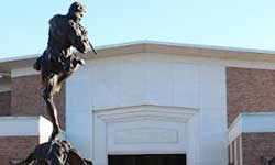 Pictured is the front entrance of the Laidlaw Performing Arts Center with the fountain and piper statue in the foreground.