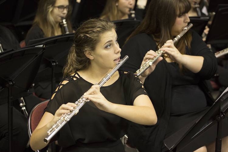 closeup of two girls playing flutes