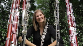 Picture in a garden both green and full of double-reed instruments is USA Faculty Dr. Rebecca Mindock.