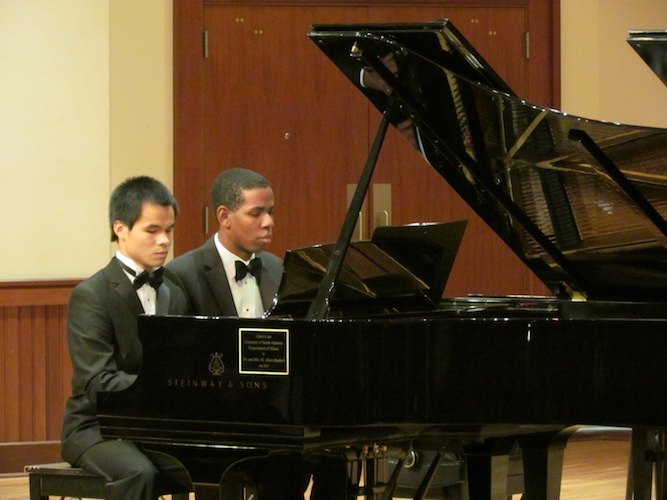 Wei Min Patrick and Joshua Vaughn seated and playing together at grand piano