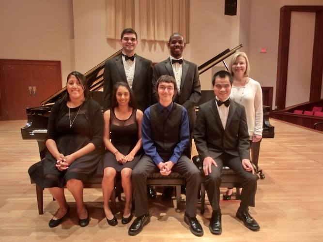 members of USA Piano Ensemble seated/standing near grand piano on stage