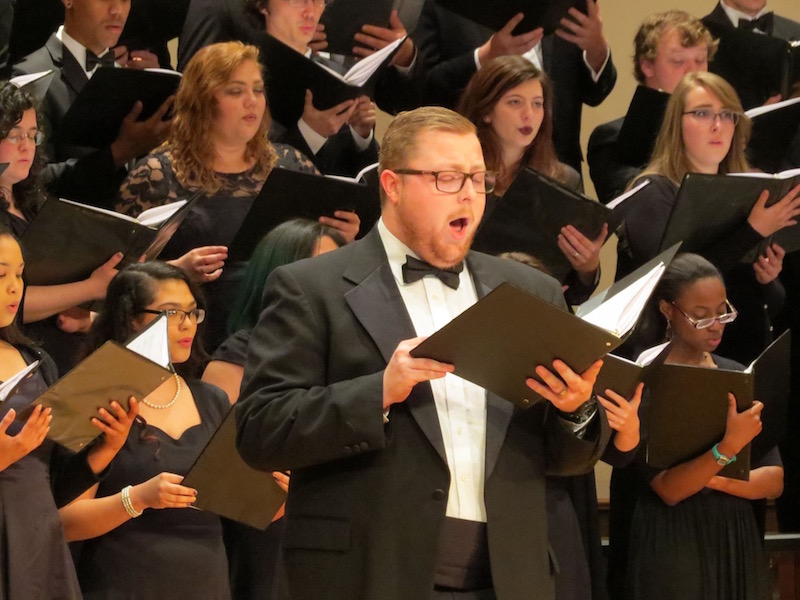 Dawson Sellers singing solo with other choir members in the background also singing