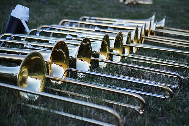 Pictured on a grassy field are trombone aligned symmetrically. data-lightbox='featured'