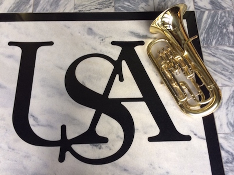 Euphonium laying beside USA logo on marble floor