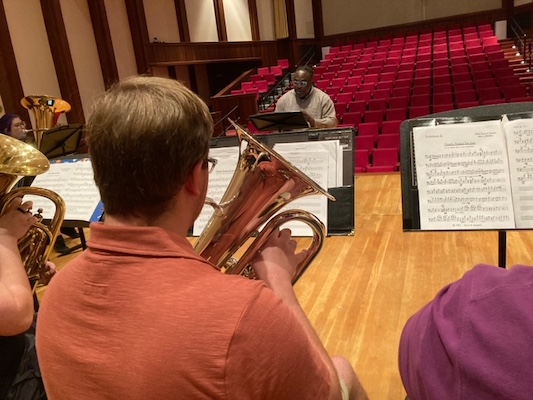 Pictured is an anonymous tenor tubist in an ensemble rehearsal with Dr. Clayton Maddox. data-lightbox='featured'