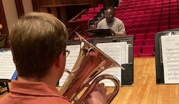 Pictured is an anonymous tenor tubist in an ensemble rehearsal with Dr. Clayton Maddox.