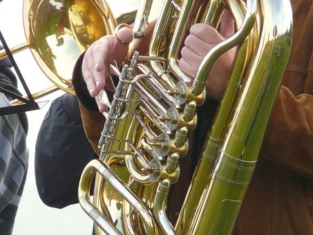 Pictured is a stock photo of a tubist showing only the valve section of the instrument and the hands of an anonymous performer. data-lightbox='featured'