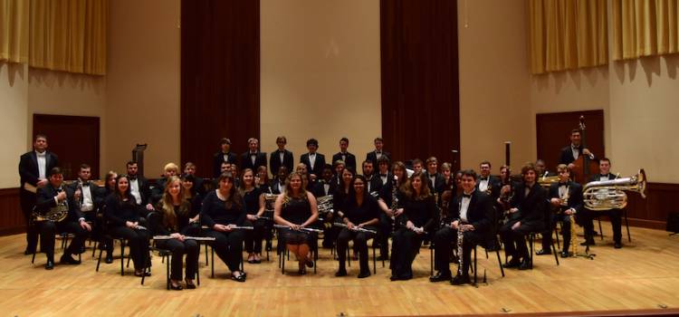 USA Symphony Band and Wind Ensemble poses on stage