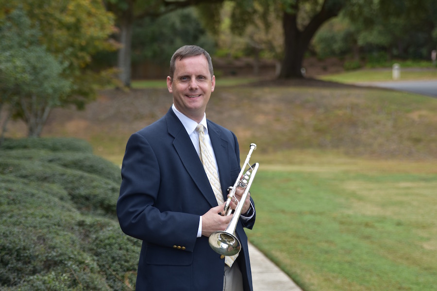 Pictured out of doors by the Laidlaw Performing Arts Center fountain is trumpeter and USA faculty Dr. Peter Wood.