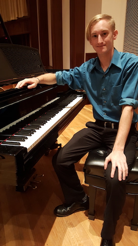 Shawn Wright seated sideways at the piano and facing camera