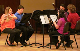 Pictured are members of the USA Woodwind Ensembles posing comically in the lobby of the Laidlaw Performing Arts Center.