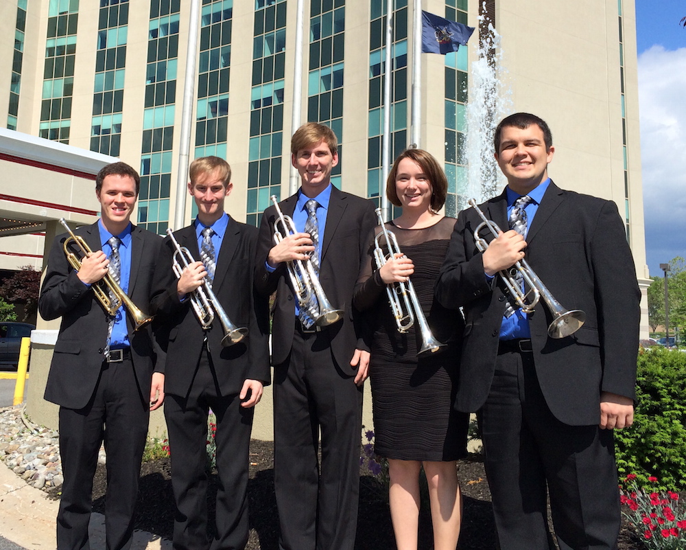 Five members of USA Trumpet Department standing outside holding their trumpets