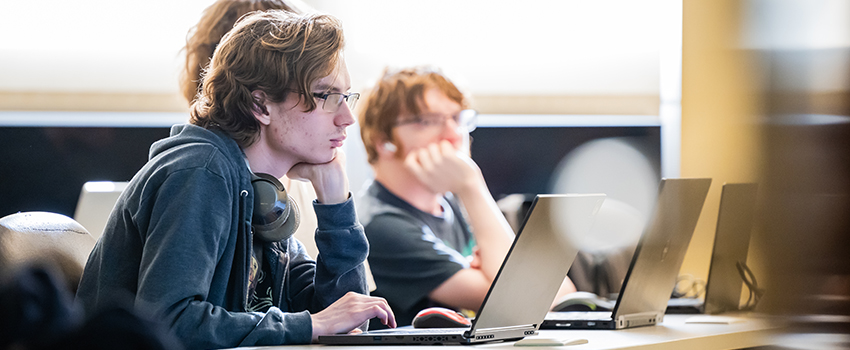 Students in class using their laptops.