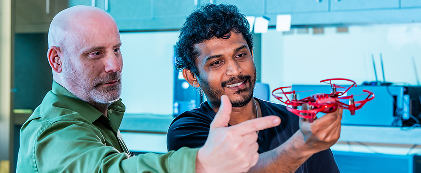 Professor working with student on drone.