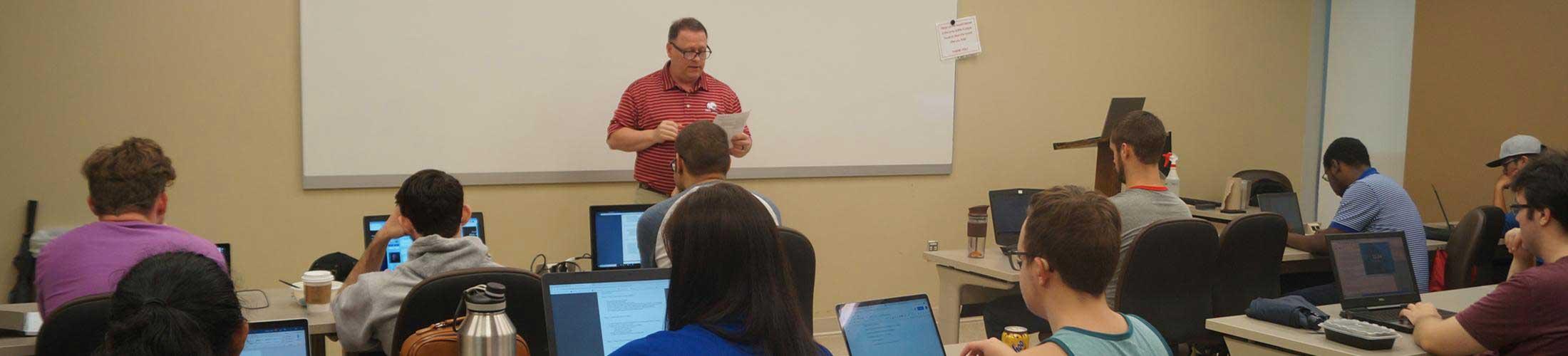 Professor in front of class teaching.