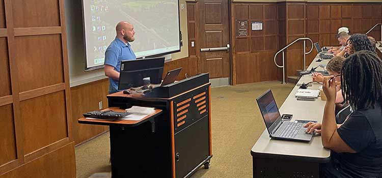 Dr. Ables teaching at from of class. data-lightbox='featured'