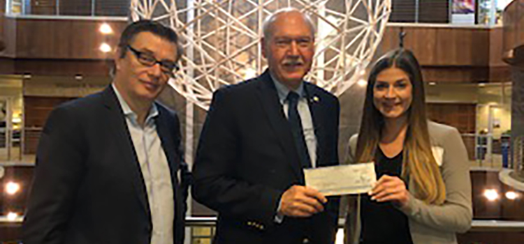 Les Barnett accepts contribution from AM/NS Calvert's Antoine Dhennin and Mallory Sikes to support the Robotics Program. data-lightbox='featured'