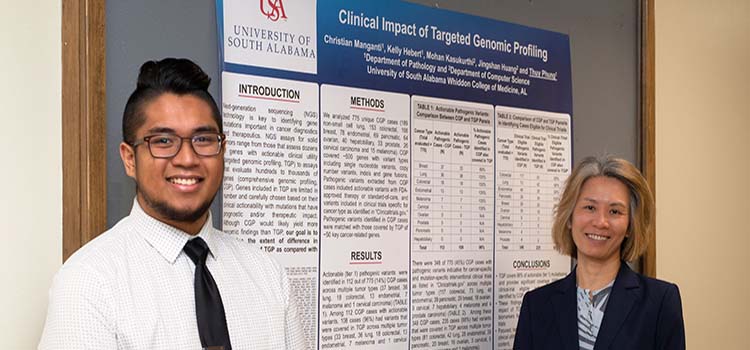 Christian Manganti, a third-year medical student, and Thuy Phung, M.D., Ph.D., associate professor of pathology, display their poster describing the clinical impact of targeted genomic profiling.  data-lightbox='featured'