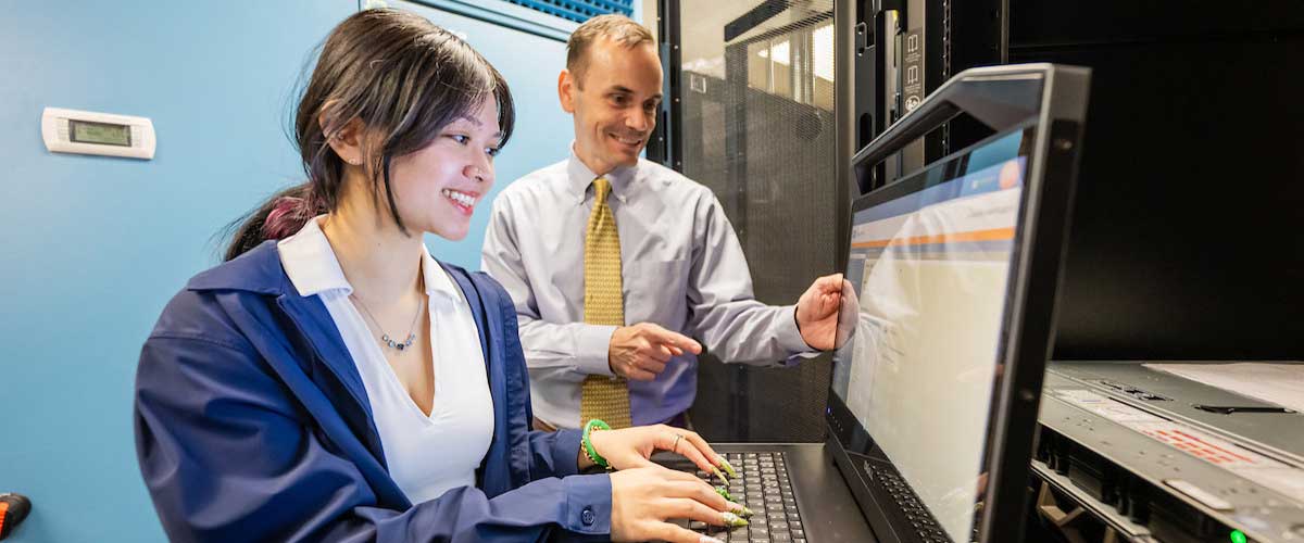 Dr. Jordan Shropshire and an SoC student using a server console in an SoC Server room