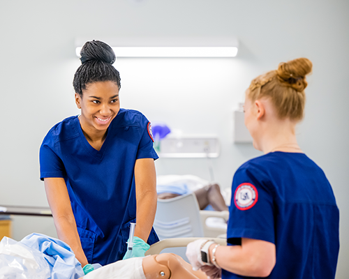 Two nursing students working in the simulation lab.