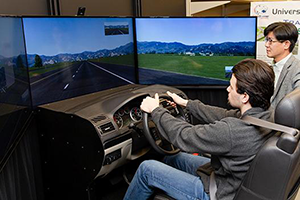 Civil Engineering student with professor driving simulator.