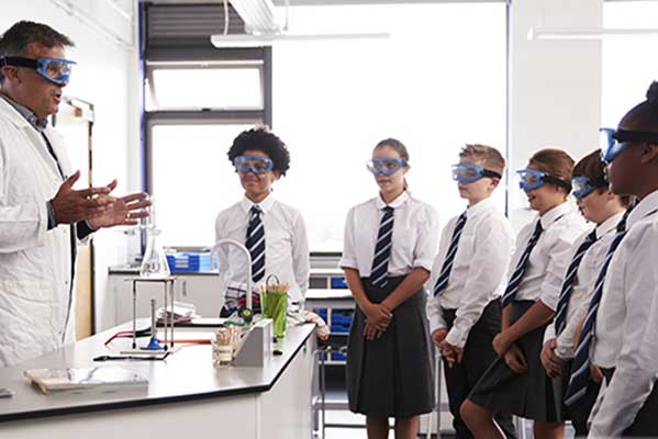 Teacher working with kids in science lab.