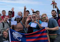 A group of students holding the Jags flag abroad.