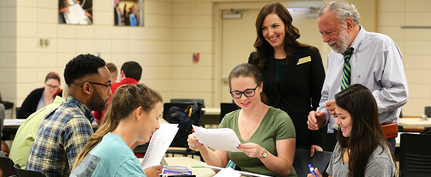 Dr. Estis and Dr, Aucoin working with students in classroom.