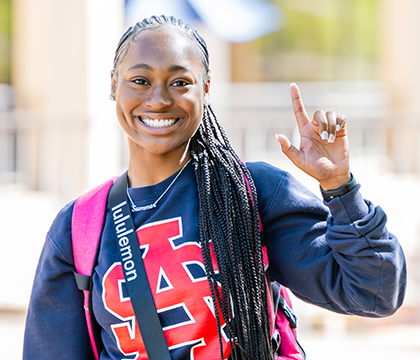 Student smiling holding up J Sign 