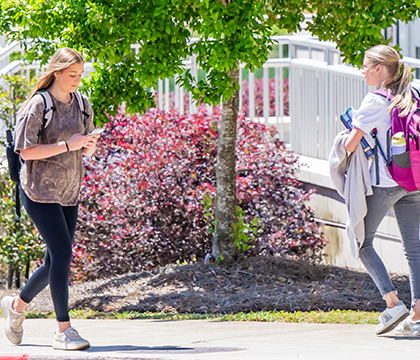 Two students walking outside of the Honors College.