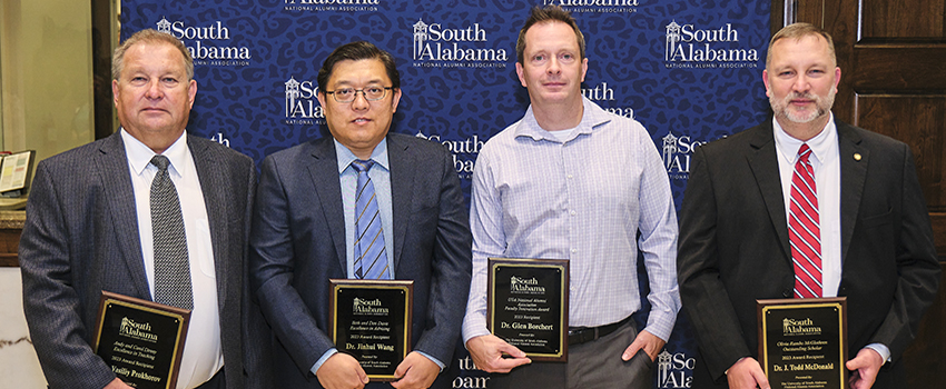 Alumni Award Winners holding their plaques.