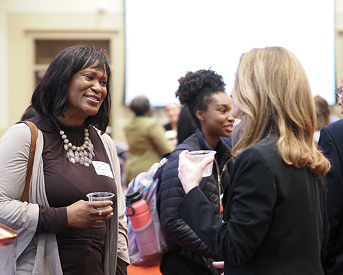Two people talking at networking event.